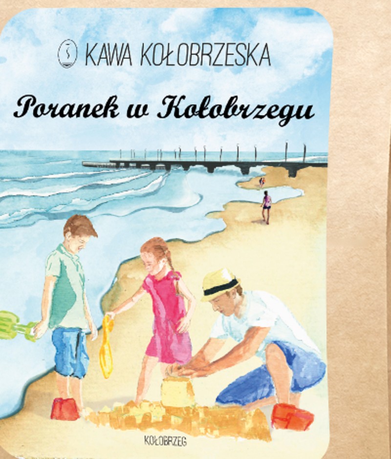 etykieta kawy Poranek w Kołobrzegu: rodzina buduje zamek z piasku na plaży, w tle molo